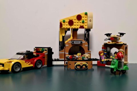 Gesamtansicht des LEGO City Sets 60496 mit Pizzaküche, Lieferauto und Sitzbereich