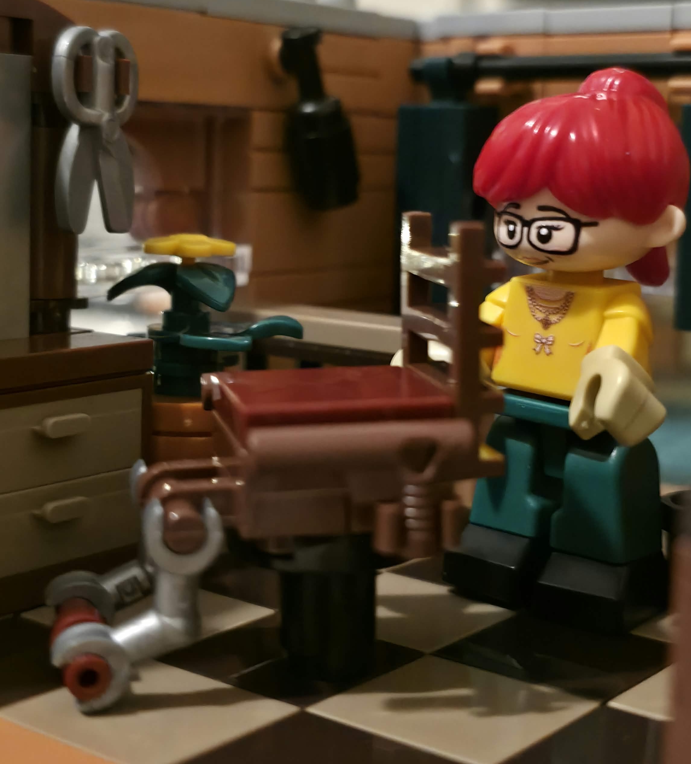 Rothaarige Figur mit Brille neben dem Friseurstuhl im IAMBRICK Hair Salon mit Schere und Schrank