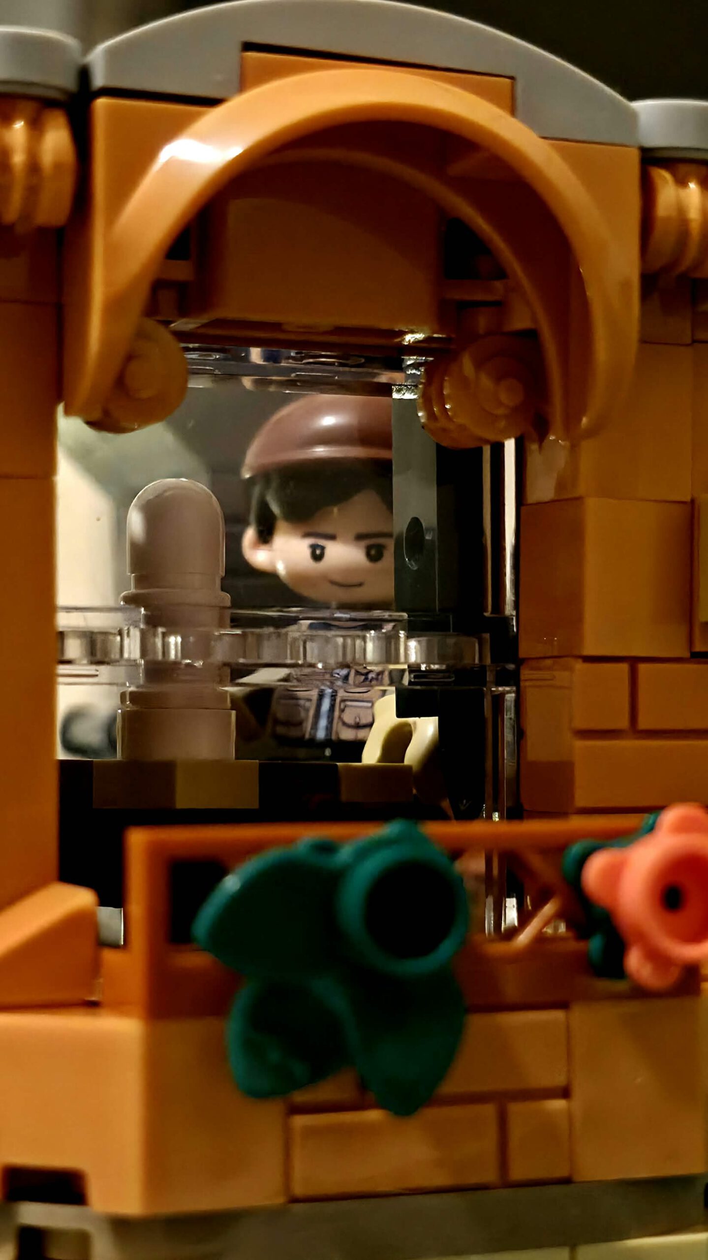 Klares Bogenfenster des IAMBRICK Hair Salons mit Figur hinter der Scheibe und dekorierter Fensterumrahmung